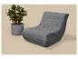 Sivé ležadlo s ružovou kvitnúcou izbovou rastlinou na béžovom pozadí.