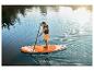 Muž na paddleboarde na jazere, užívajúci si slnečné počasie