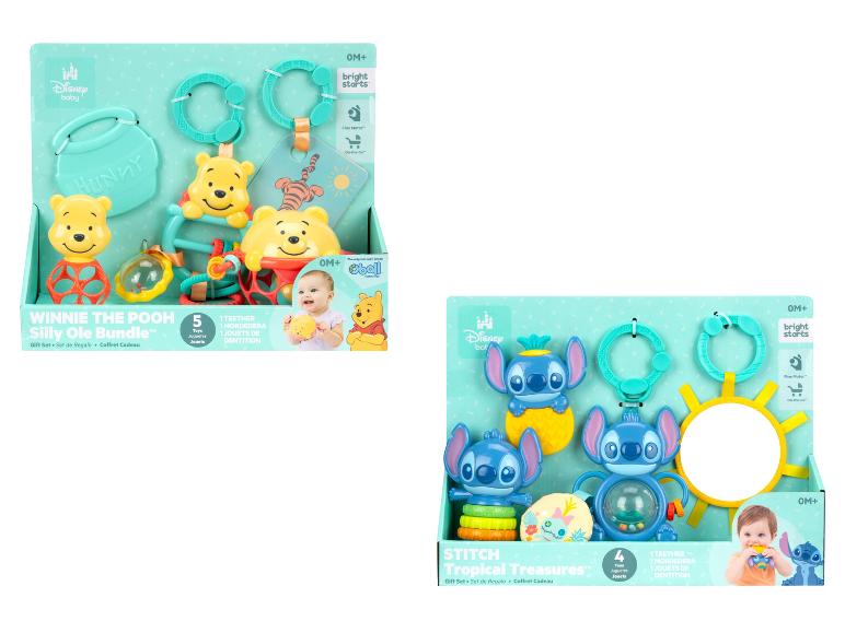 Dve darčekové sady pre bábätká, jedna s hračkami Macka Pú a druhá s hračkami Stitch.