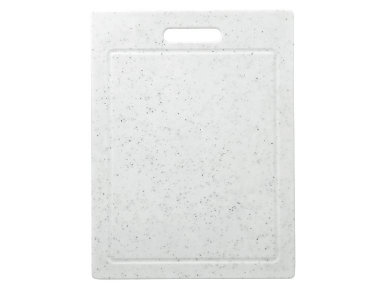 Biela doska na krájanie s čiernymi bodkami a vyrezanou rukoväťou