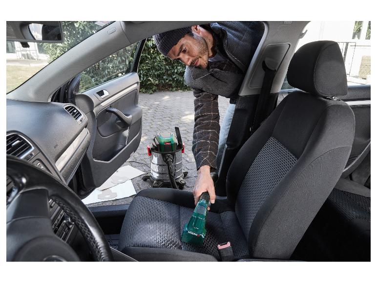 Muž čistí autosedačku s mokro-suchým vysávačom Parkside.