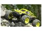 Žlto-čierny monster truck Extron šplhá po skalách.