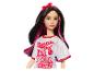 Barbie bábika s ružovými prameňmi a červeným tričkom s nápisom 'Twist Up the Volume'.