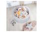 Dieťa sedí v sivom bazéne s farebnými loptičkami.