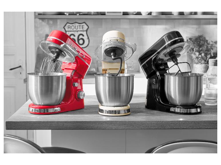 Tri retro stojanové mixéry v červenej, krémovej a čiernej farbe na kuchynskej linke.