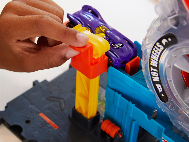 Dieťa si hrá s autíčkom Hot Wheels a pretekárskou dráhou.