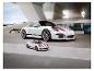Biely Porsche 911 GT3 a menší model puzzle pred modernou budovou.