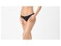 Žena v čiernych nohavičkách, pózujúca s rukami na stehnách.