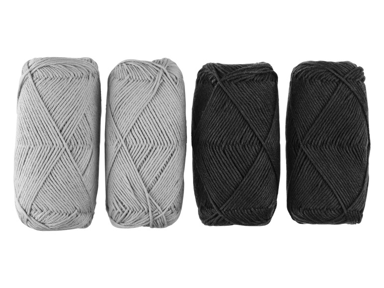 Dve guľôčky sivej priadze a dve guľôčky čiernej priadze.