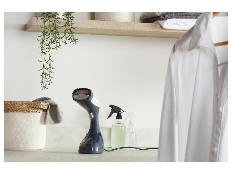 Ručný naparovač odevov na pulte s bielou košeľou, košom a rozprašovačmi.