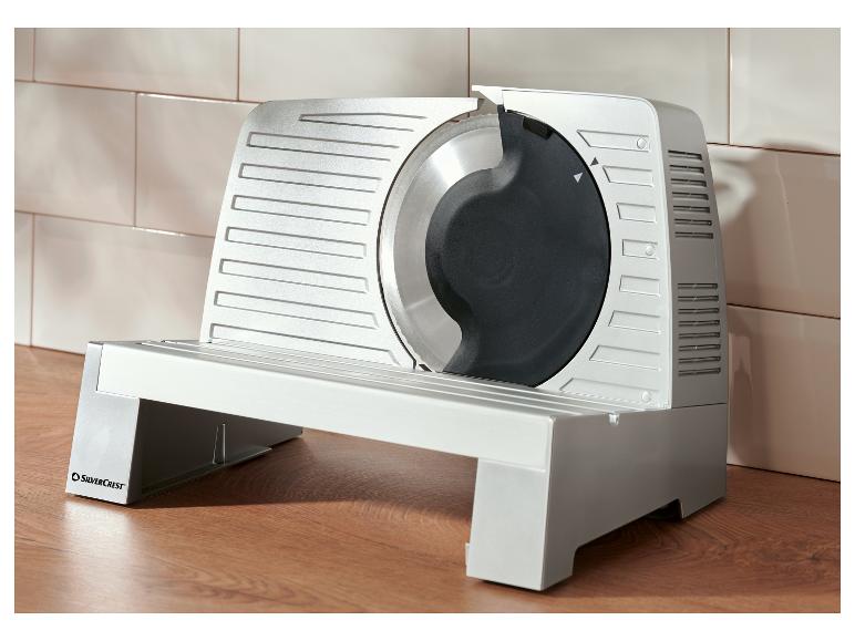 Krájač mäsa SilverCrest na drevenej doske pri obloženej stene