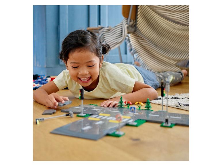Dievča si hrá s LEGO® City: cesty, semafory a rastliny.