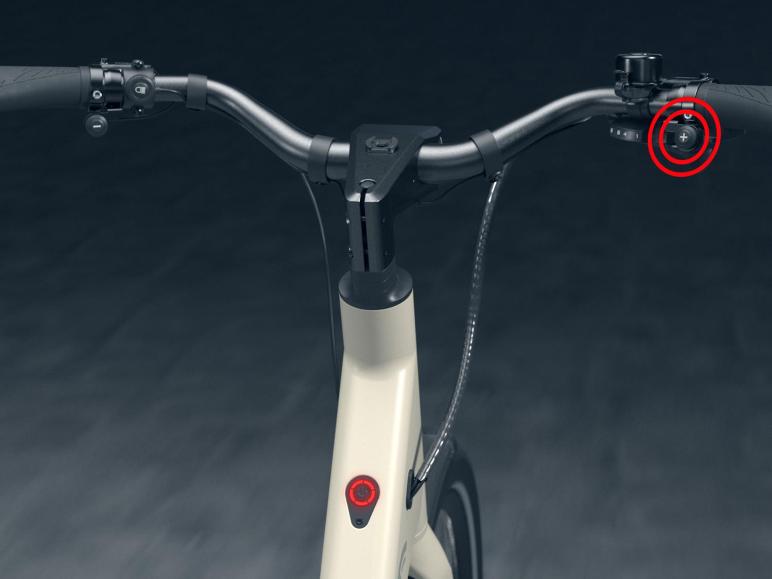 Detailný pohľad na riadidlá bieleho elektrického bicykla.
