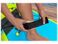 Osoba si dáva čierny remienok na členok na nafukovací paddleboard.