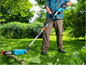 Muž používa elektrickú pílu Gardena v záhrade.
