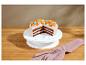 Čokoládová torta s bielou polevou, kumkvátmi a farebnými cukríkmi na stojane na torty.