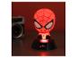 Červeno osvetlená nočná lampa Spiderman na čiernom podstavci, s rozostreným fotoaparátom v pozadí.