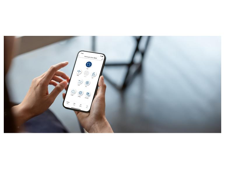 Osoba drží smartfón zobrazujúci aplikáciu robotického vysávača s rôznymi možnosťami ovládania.