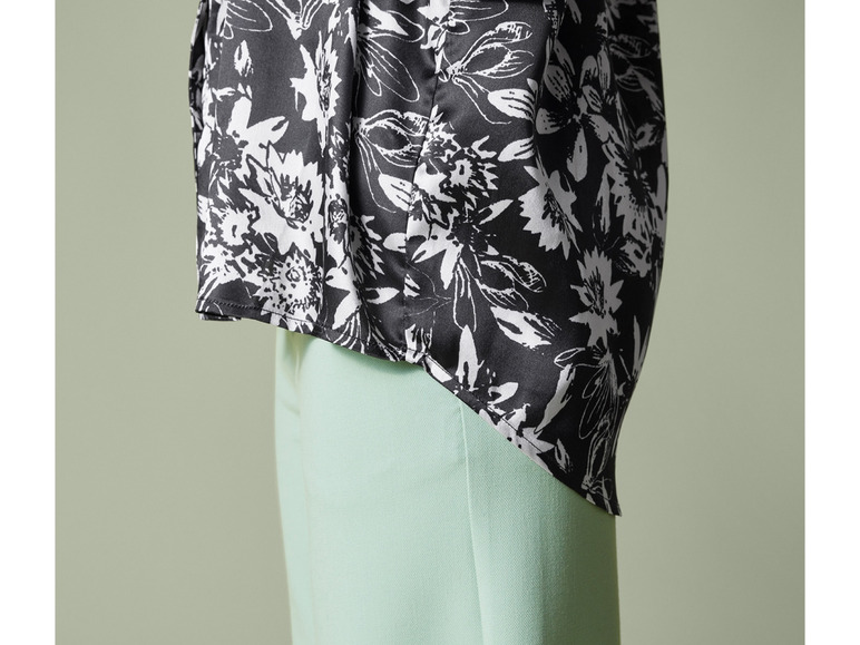 Čierna blúzka s bielym kvetinovým vzorom a svetlozelené nohavice.
