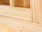 Detail drevenej skrinky so sklenenými dverami.