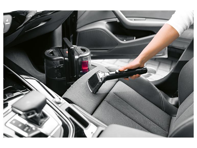 Ručný čistič textilu čistí autosedačku.