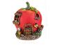 Dekoratívny domček pre víly v tvare paradajky s oknom, dverami, kvetmi a húsenicou navrchu.
