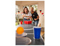 Dvaja ľudia hrajú beer pong s oranžovou loptou a červenými pohármi.