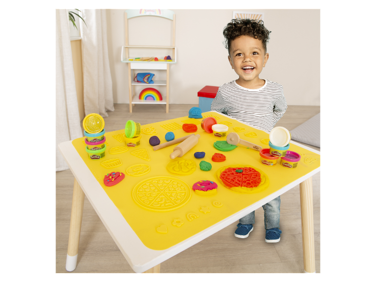 Dieťa si hrá s modelovacou hmotou Play-Doh pri stole so špeciálnou podložkou.