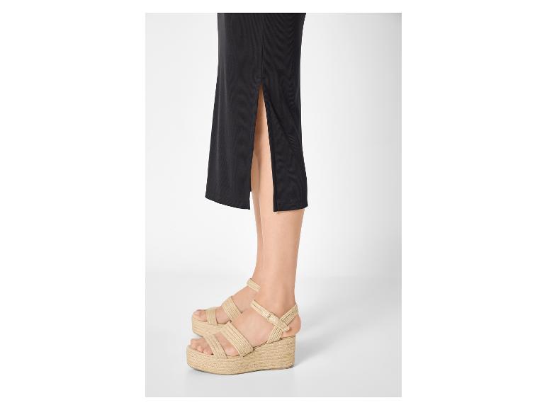 Žena v čiernej sukni a espadrilkových sandáloch na platforme
