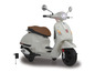 Biela elektrická Vespa s nabíjačkou.