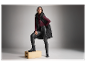 Modelka v čiernej prešívanej veste, bordovej mikine a kožených nohaviciach.