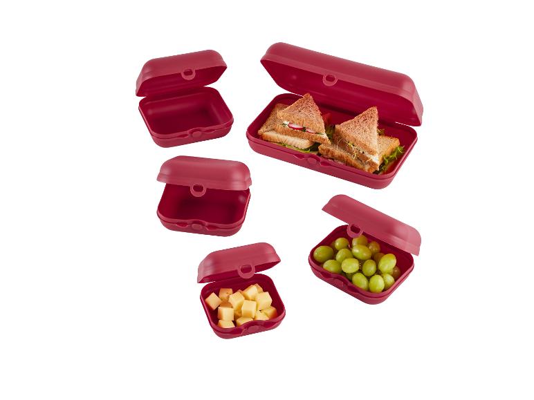 Červené obedové boxy so sendvičmi a hroznovým vínom.