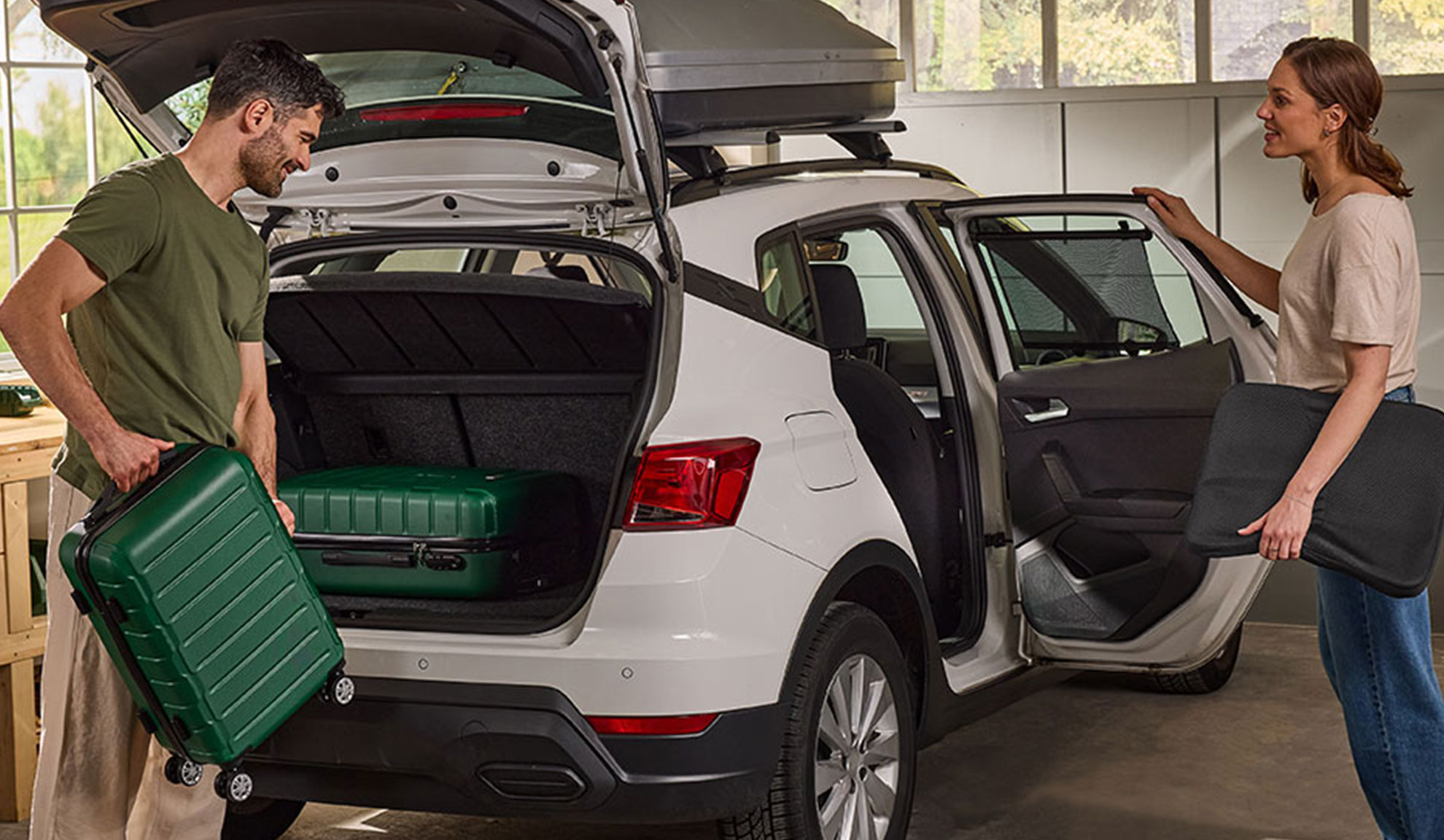 Pár balí batožinu a autopríslušenstvo do bieleho SUV na výlet.