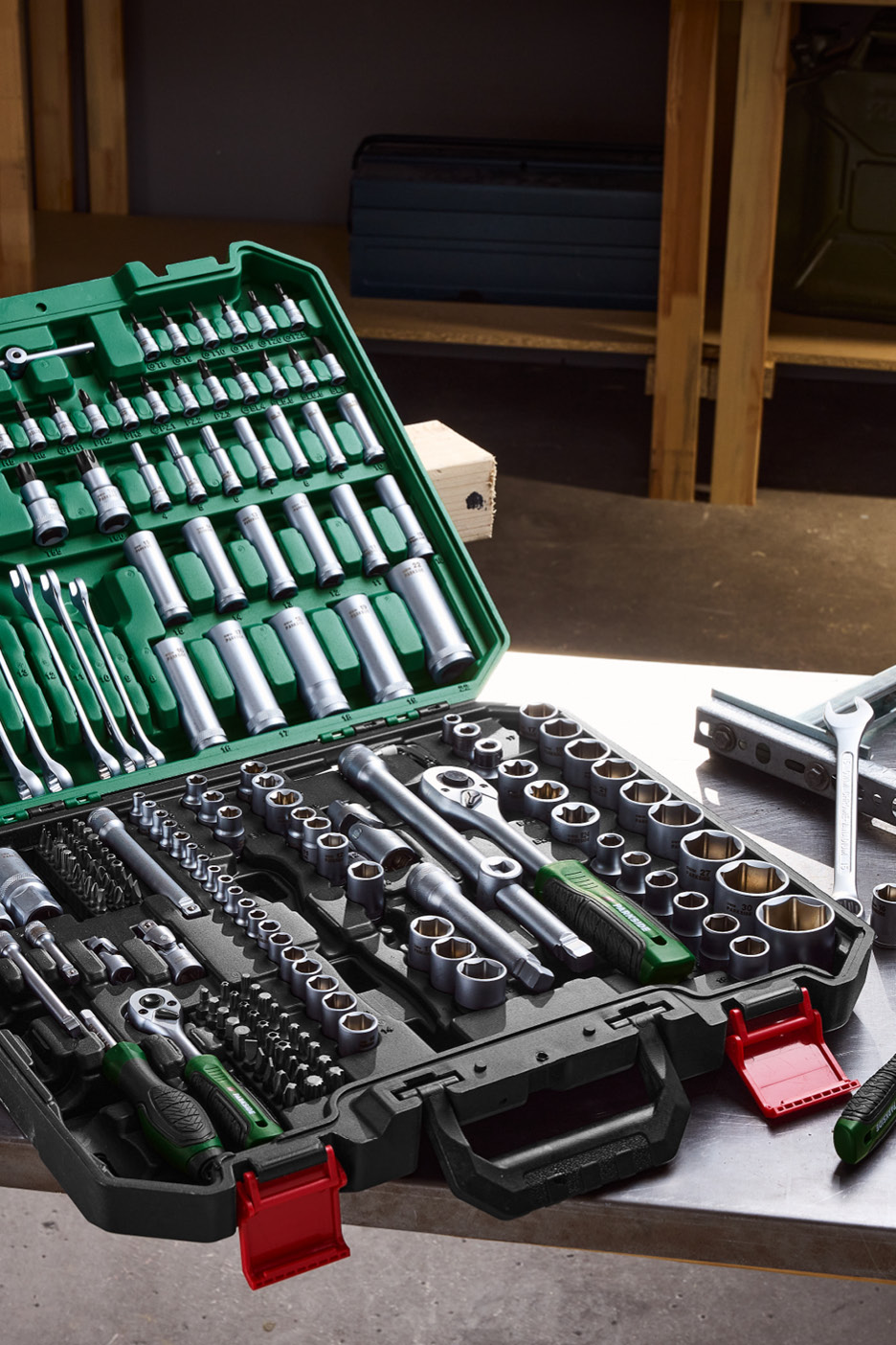 Otvorená súprava náradia Parkside s kľúčmi, nástrčnými hlavicami a skrutkovačmi na kovovom stole.