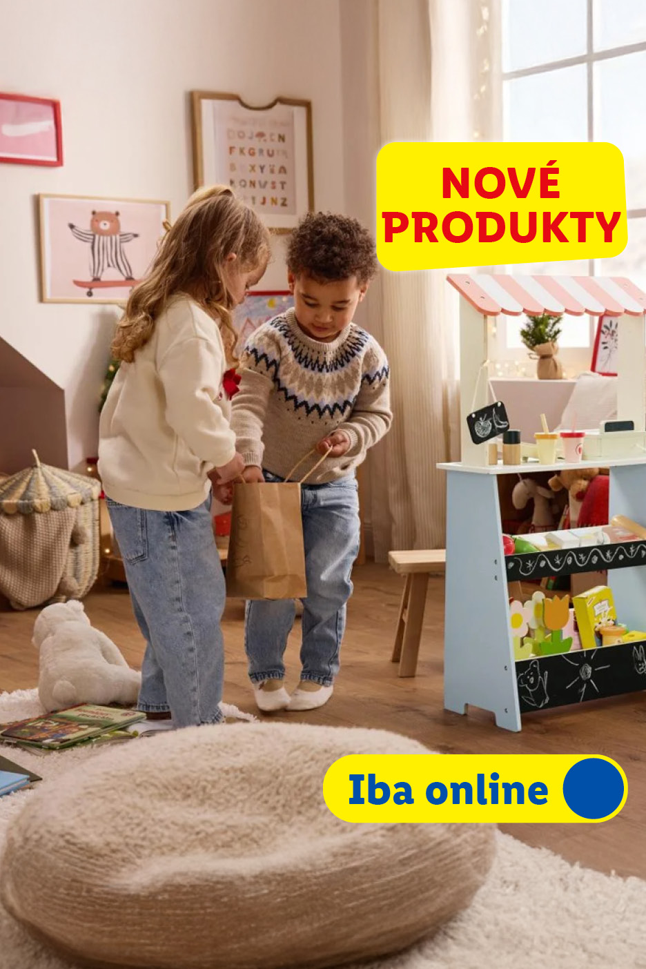 Deti sa hrajú s dreveným stánkom a nákupnou taškou, v pozadí vianočná výzdoba.