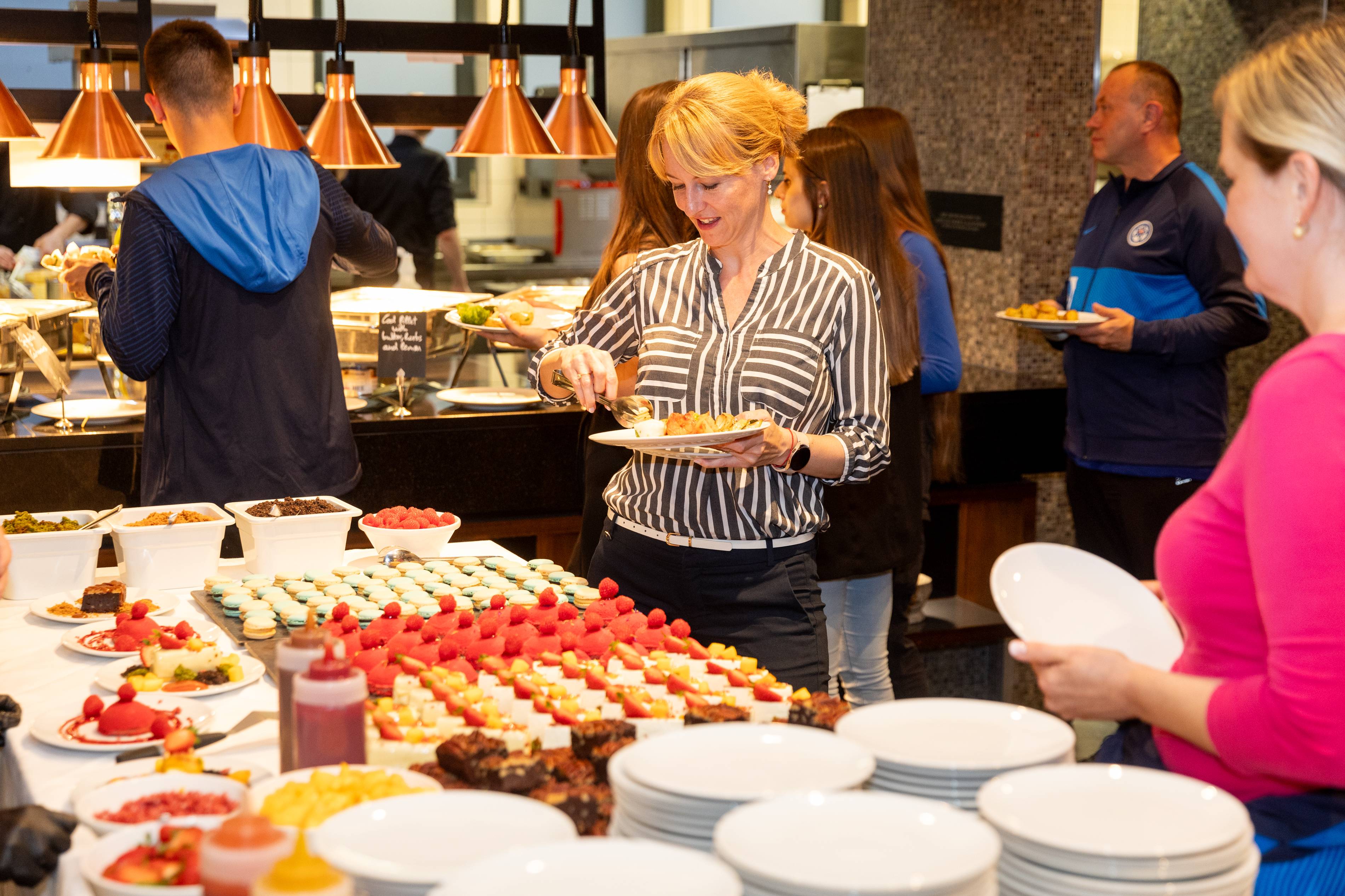 Rozmanitý bufet: makrónky, koláče, dezerty s červeným ovocím.