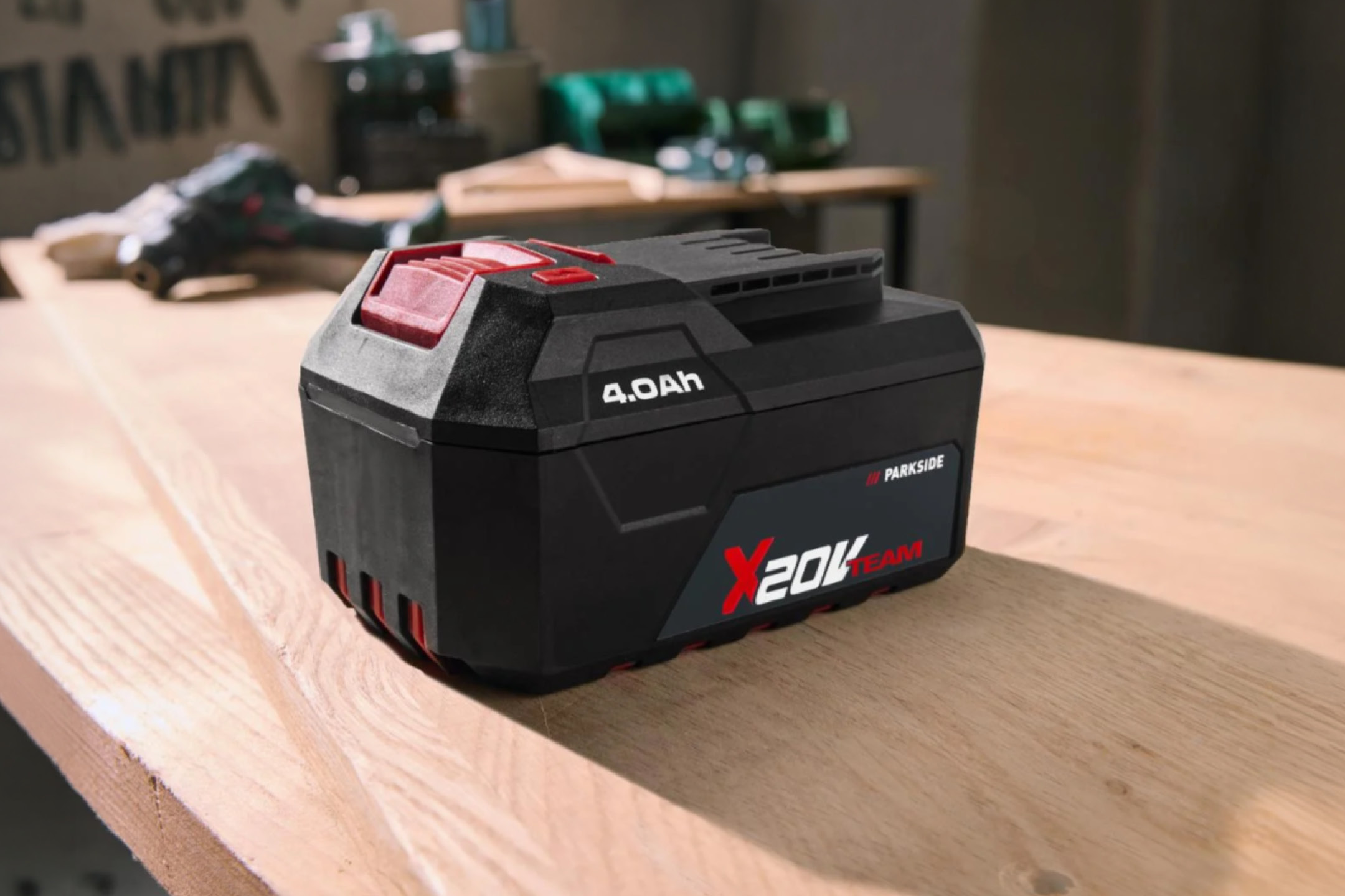 Čierna batéria s červenými prvkami a nápisom „4.0Ah X 20V TEAM“ na drevenom stole.