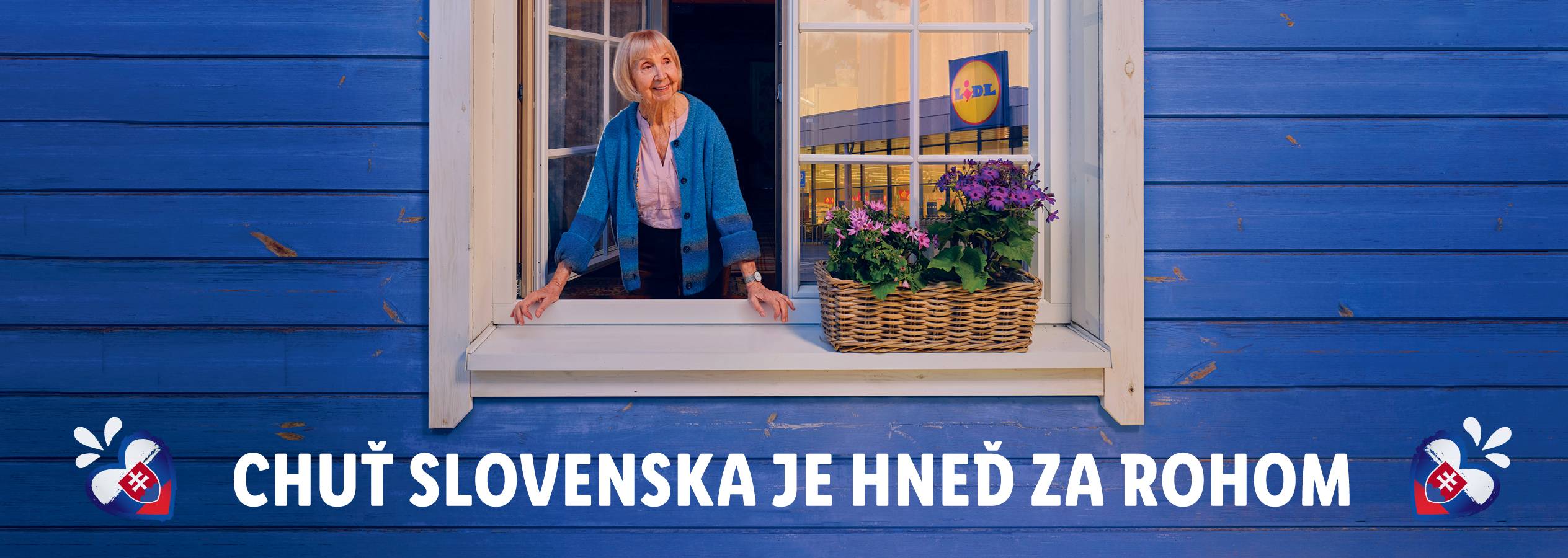 Žena sa pozerá na Lidl z okna.