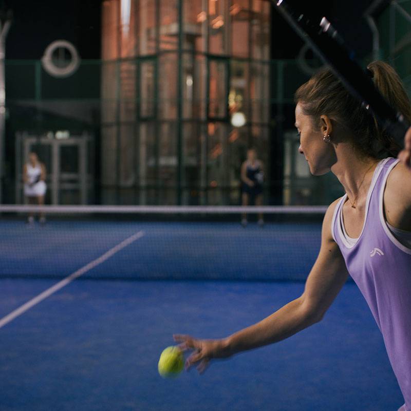 Padel tenis: hráčka s raketou, loptičky