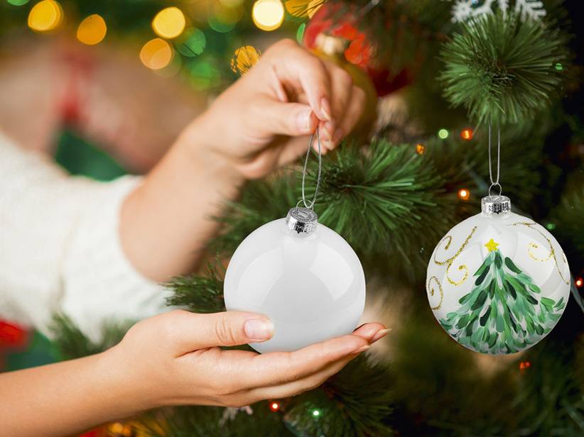Vianočné ozdoby: biele a maľované sklené gule so stromčekom.