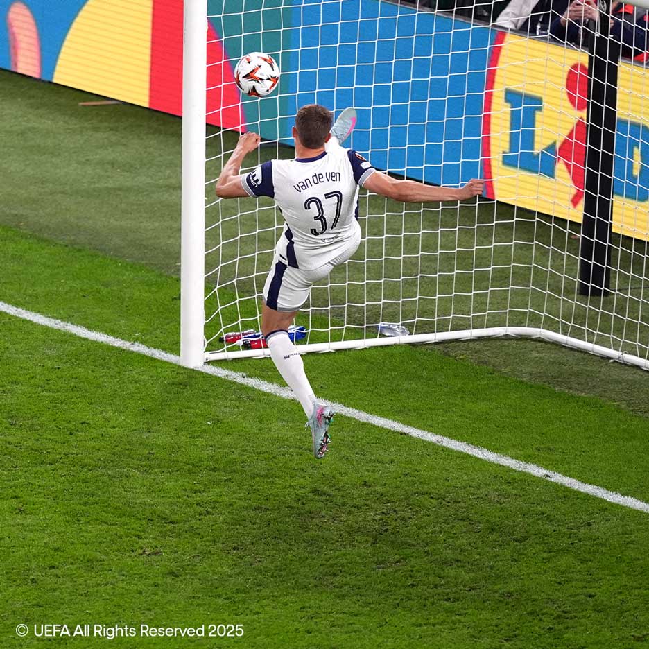 Futbalista v bielom drese s číslom 37 kope loptu do brány.