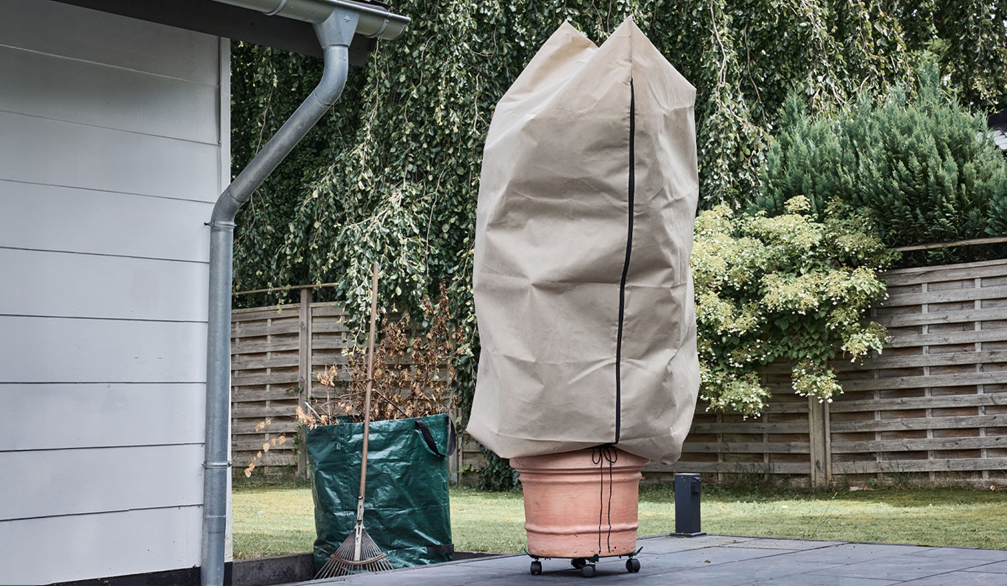 Obal na rastliny v kvetináči na terase s odkvapom a hrabľami.