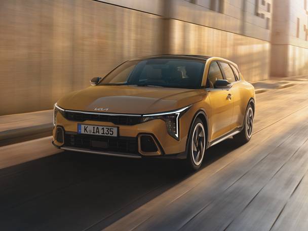 Zlaté auto na ceste s rozmazaným pozadím.