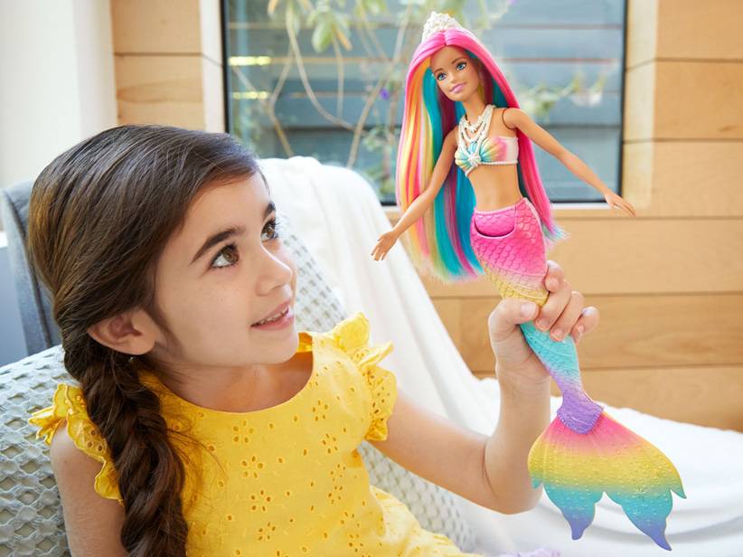 Dievča si hrá s dúhovou morskou pannou Barbie.