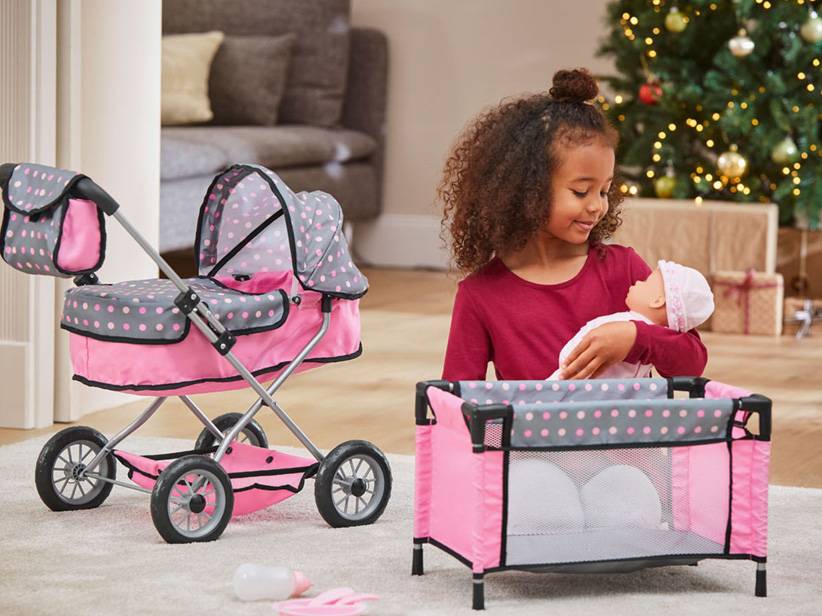 Ružový kočík a postieľka pre bábiky so sivými bodkami.