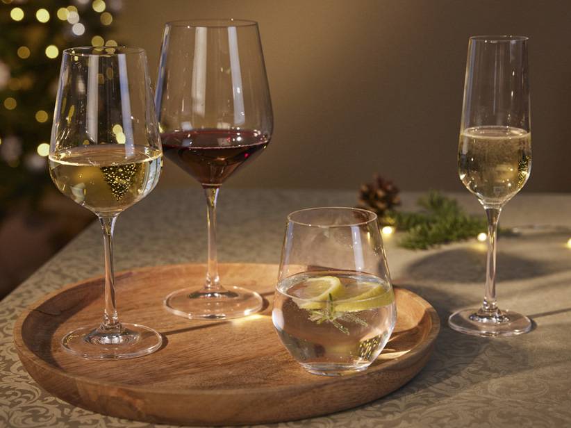 Poháre na červené a biele víno a pohár na šampanské na drevenom podnose.