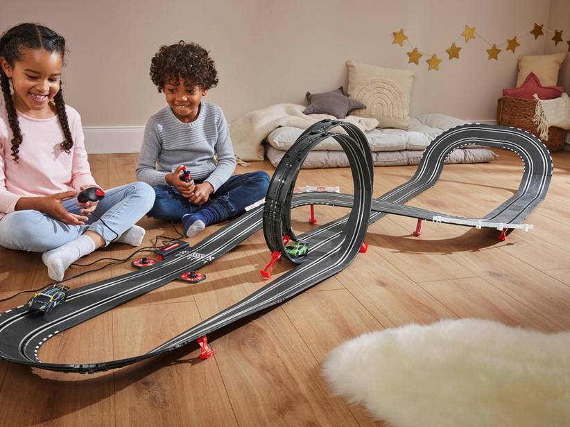 Deti sa hrajú s autíčkami a pretekárskou dráhou.