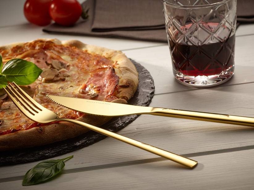 Zlatý príbor Royalwerk s pizzou.