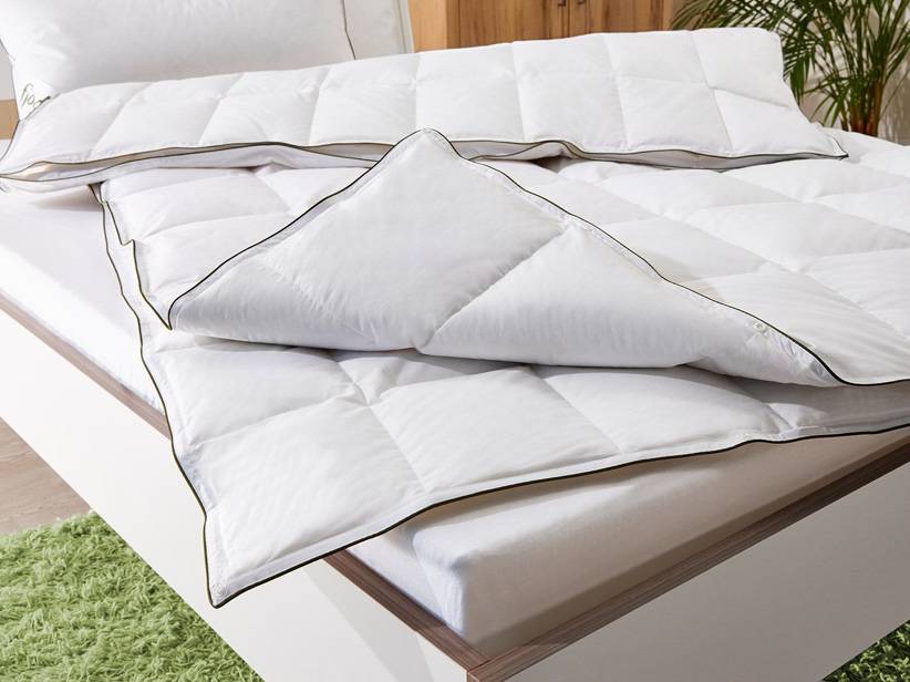 Biele periny a vankúše, čierny lem.