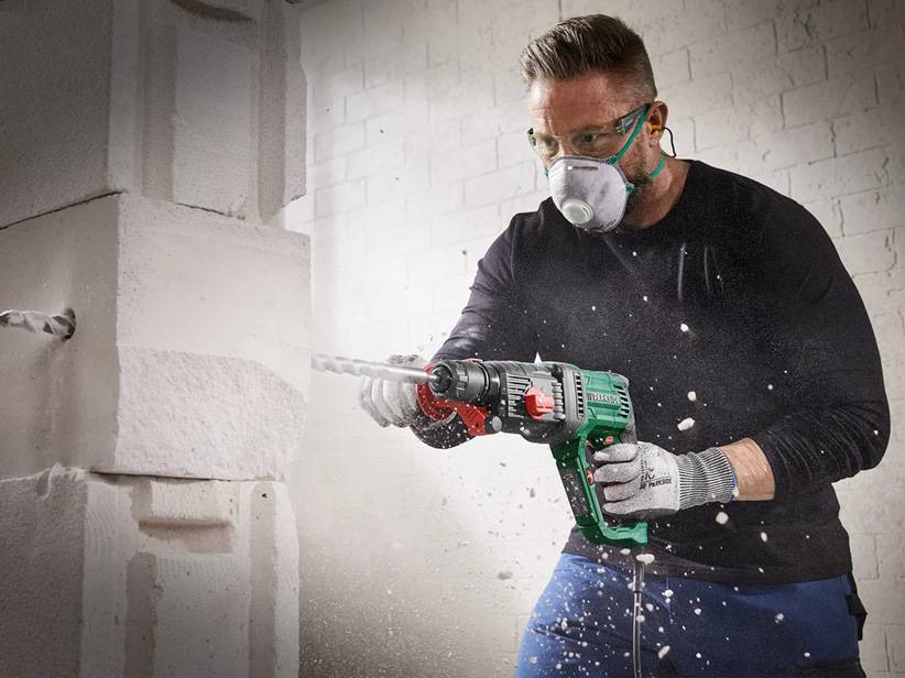 Muž používa rotačné kladivo Hilti na vŕtanie do steny.